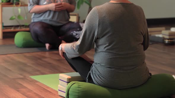 Woman Sitting in Lotus Position with Bolster