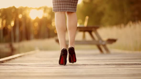 Business Woman in Skirt and High Heels Walks Towards Laptop Close Backside View