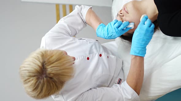 Beutician Doctor Wiping Patient's Face with Cotton Pads