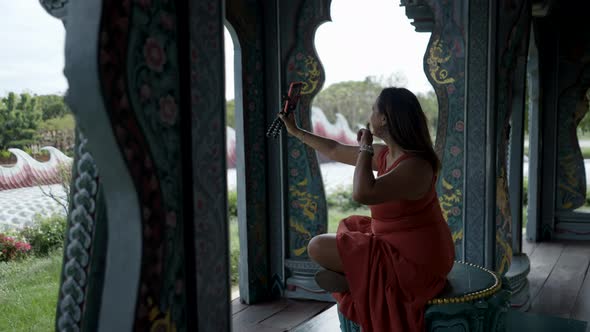 Woman Taking Selfies On Her Smartphone At Ancient City Museum Park Thai Ban Mai Thailand  Pullback