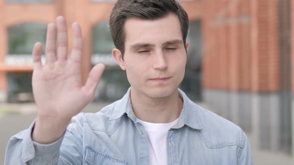 Stop Gesture by Young Man Standing Outdoor