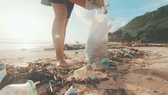 Ecoactivist Walks Barefoot on Sea Sand and Collects Discarded Plastic Bottles