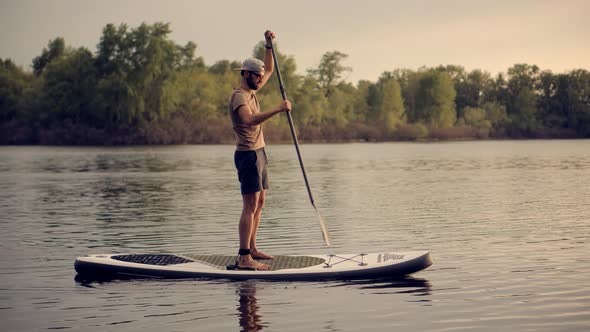 Man Sup Surfing. Stand up Paddling Surfboard. Inflatable Board For Rowing. Surfer Balance Watersport
