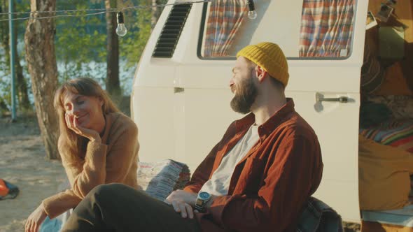 Couple Talking by Van at Campsite