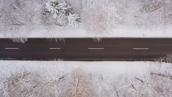 Car from above is driving fast over a wintry road with snow at its roof