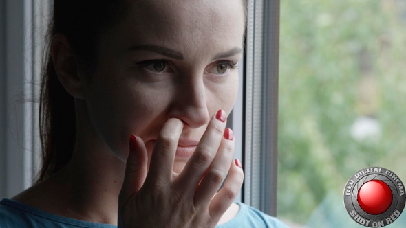 Woman Picking Nose With Red Nails Standing By The Window
