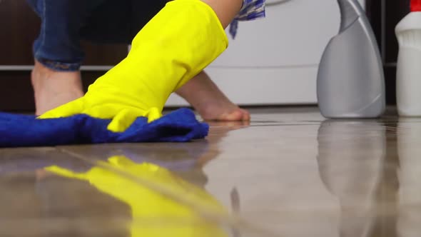 young woman in close-up washes squatting or kneeling on floor.