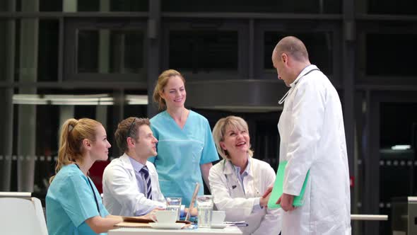 Doctor shaking hands and interacting with colleagues in conference room