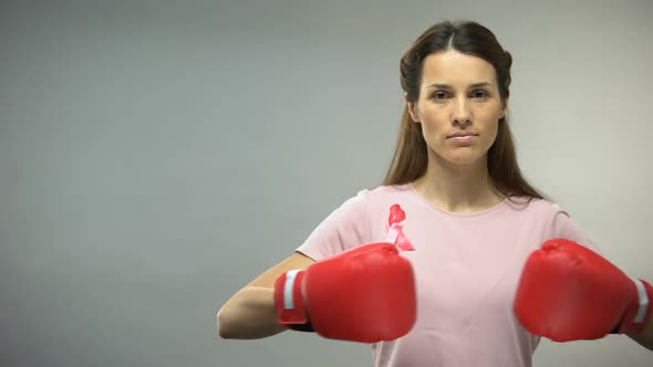 Woman With Pink Ribbon in Boxing Gloves, Fighting Against Breast Cancer Concept