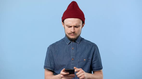 Portrait of Handsome Hipster Man Using Cell Phone and Chatting or Browsing Internet Isolated Over