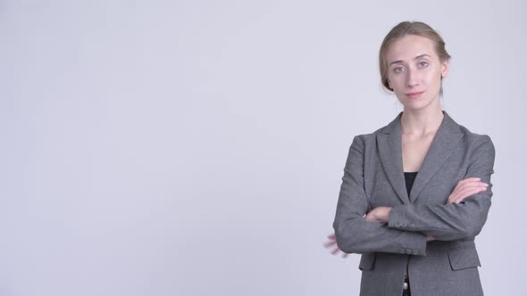 Profile View of Happy Young Blonde Businesswoman Smiling with Arms Crossed