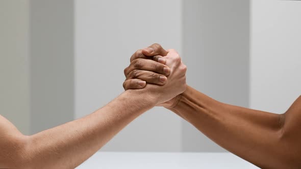 Two Hands Joining Together and Doing Arm Wrestling Isolated Over White Background in Slow Motion