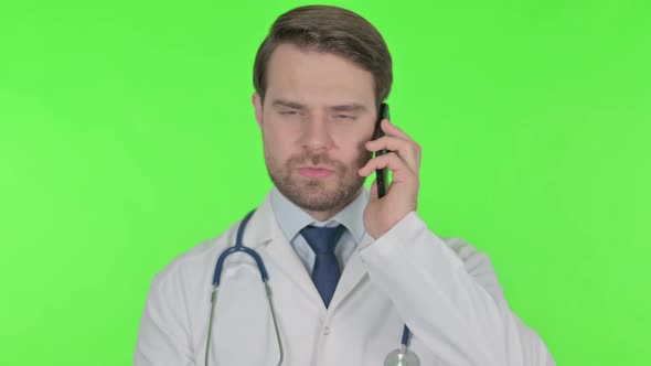 Young Doctor Talking on Phone on Green Background