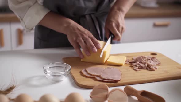 Slicing Hard Cheese. Women's Hands Cut Cheese, Meat Table. Dinner Preparation. Man Prepares Dinner