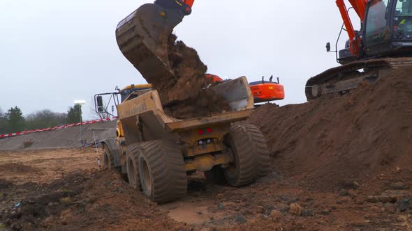 Excavator loading soil on to dumper