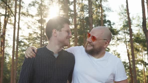 Homosexual Couple Dating in Nature. Portrait of Two Affectionate Gay Men in Love Wearing Sunglasses