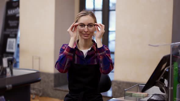 Portrait of a Woman in Eyeglasses Working at the Checkout in a Supermarket