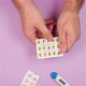 Male hands hold a blister with round yellow pills on a pink background with other medications - VideoHive Item for Sale