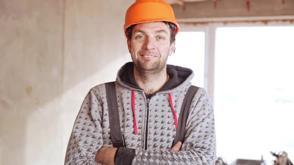 Middleaged Caucasian Male Worker Wearing Orange Hard Hat Standing with Folded Hands in Slowmotion