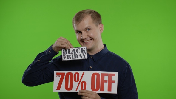 Shocked Amazed Store Client. Man Showing Black Friday and Up To 70 Percent Off Inscriptions Signs