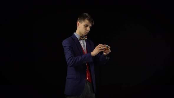 Attractive Guy in Suit Is Solving Rubik's Cube in Dark.