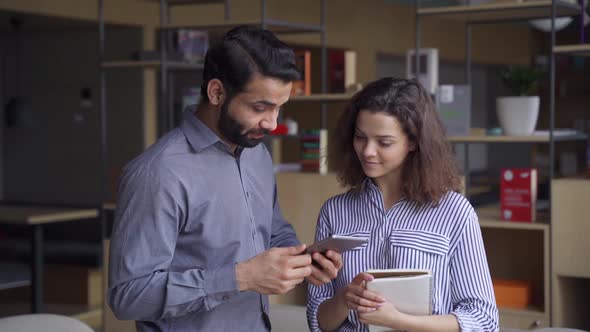 Two Happy Diverse Professionals Talking Giving High Five Standing in Office