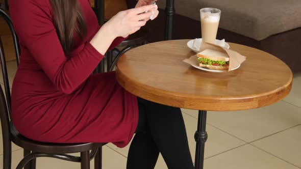 Waiter Brings the Dish and Trendy Woman Wearing Red Dress in a Cafe Make Photo of Sandwich Food with
