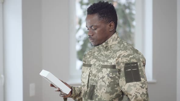 Side View Portrait of Upset Young African American Military Man Looking at Picture Thinking