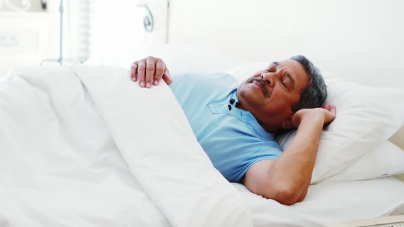 Senior man sleeping peacefully on bed 4k