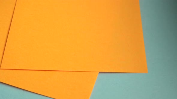 4k video, Orange square sheets of note paper neatly placed on a blue background