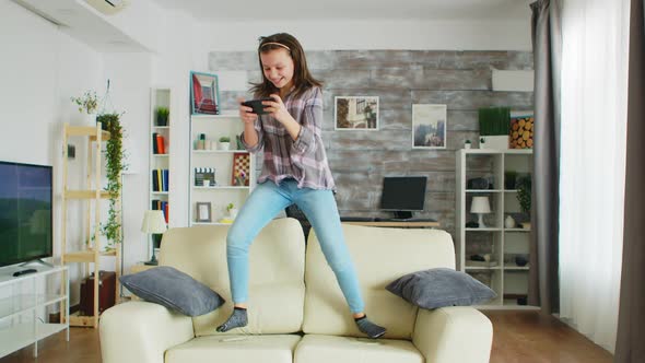 Little Girl Jumping on the Couch in Living Room