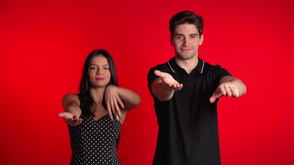 Young Couple Dancing Funny Meme Dance on Red Studio Background. Love Happiness