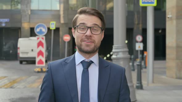 Portrait of Businessman Talking on Online Video Call, Walking in Street