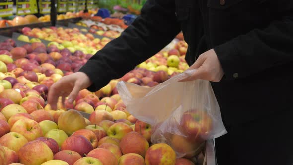 Woman Buying And Picking Apple At Supermarket Using Plastic Bag.