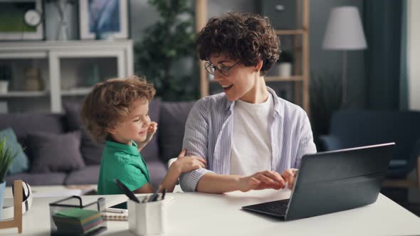 Female Freelancer Working with Laptop Then Playing with Little Child at Home