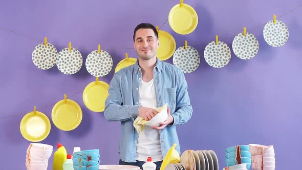 Handsome Cheerful Man Wiping Plate with Towel in the Kitchen