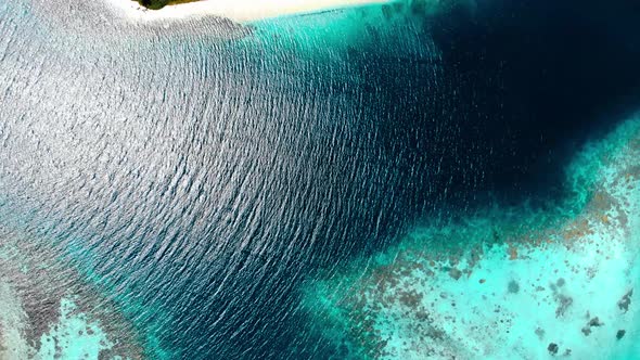 Aerial: flying over desert island tropical beach caribbean sea coral reef sunset