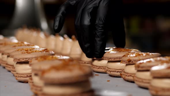 Chef Is Assembling Caramel Macarons, Close-up.