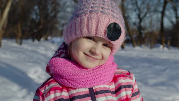 Joyful Little Child Girl Looking at Camera Smiling Fooling Around Making Faces in Winter Park