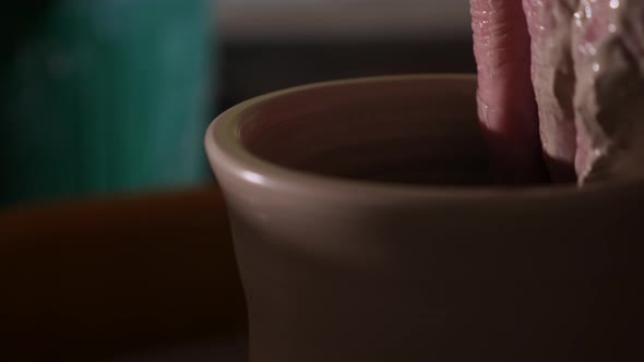 Artist handcrafting pottery made out of clay on a wheel
