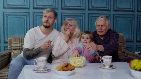 Multigenerational Family Watch TV with Young Girl Kid at Home Getting Scared Watching Horror Movie