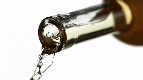 Super Slow Motion Detail Shot of Pouring White Wine From Bottle Isolated on White at 1000Fps.