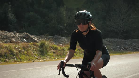 Cyclist climbing uphill on road bicycle.