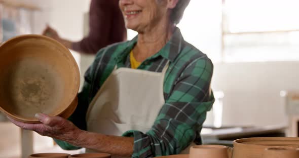 Female potter examining a earthenware pot