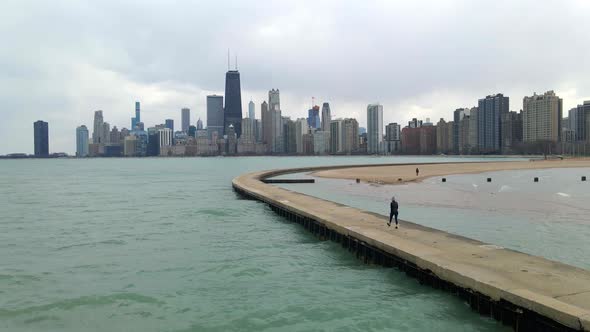 person walking in lake michigan, chicago downtown seen in the background, travel and visit illinois