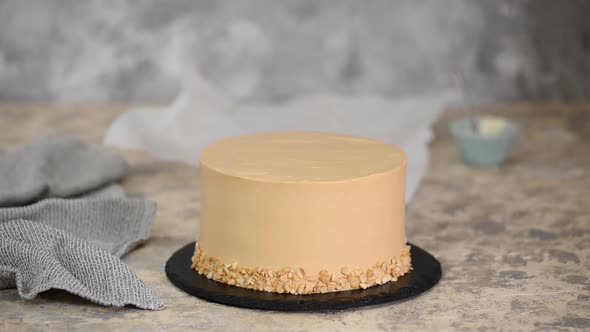 Pastry chef decorating the cake with a caramel vase.