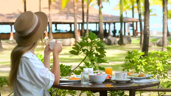 Beautiful Girl Have Breakfast at Outdoor Cafe with Amazing Tropical Island View