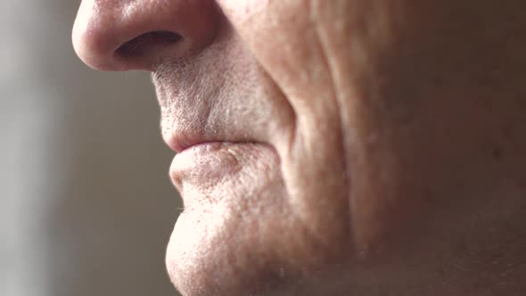 Close-up part of the face of a Caucasian pensioner in profile. Lips of an elderly person. Wrinkled f