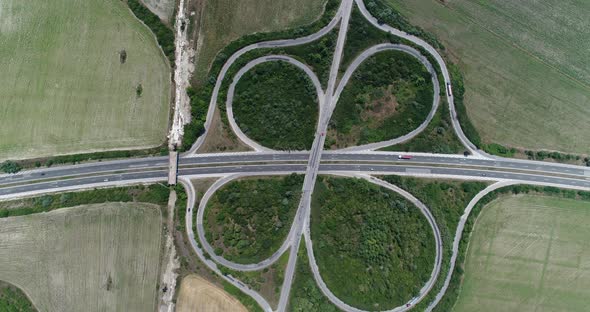 4K aerial footage of highway intersection. Road junction with traffic. Top down view