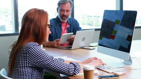 Male and female executives working together at desk